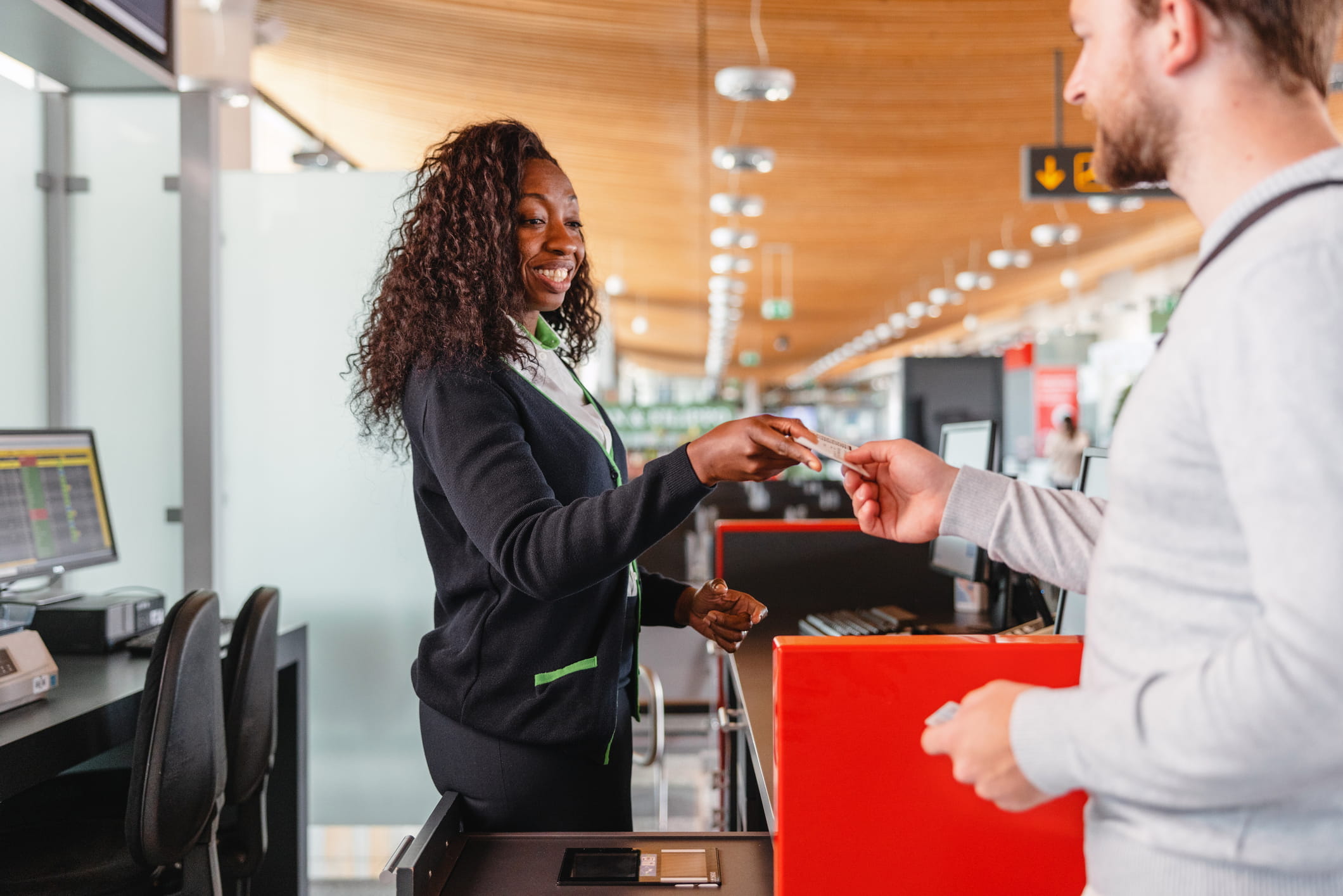 Airline worker handing man his ticket