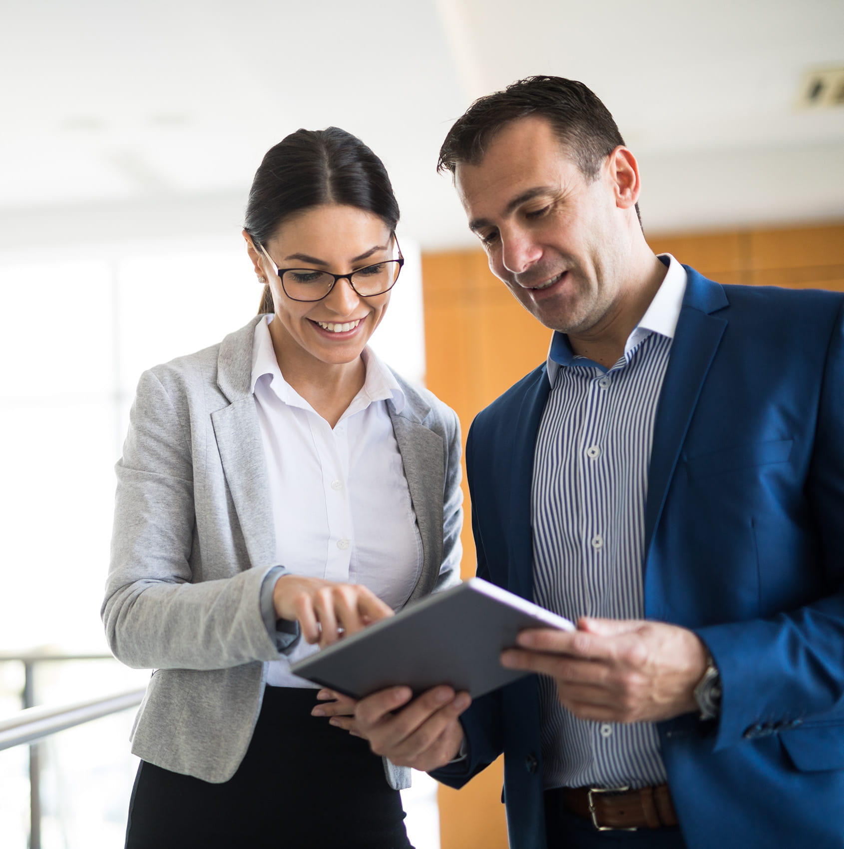 two business people reviewing information on a tablet