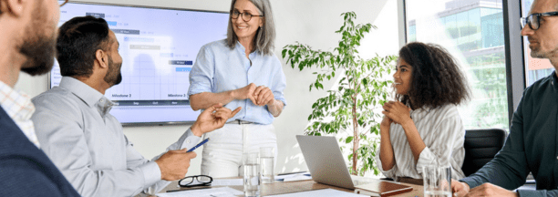 Female leader talking to employees in a conference room.