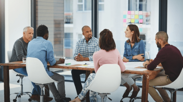 Group of employees at conference table.