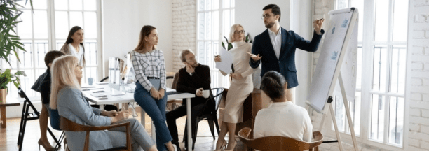 Group of employees of all ages working in a conference room together.