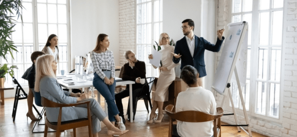 Group of employees of all ages working in a conference room together.