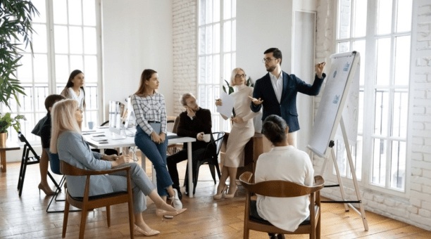 Group of employees of all ages working in a conference room together.